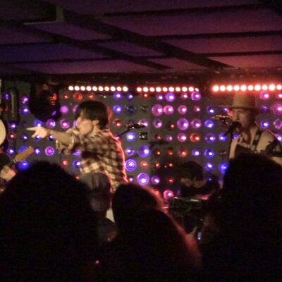 mary shelley, a rock band performing in front of purple lights